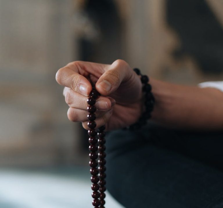 A person holds Islamic prayer beads in quiet reflection, showcasing faith and spirituality.