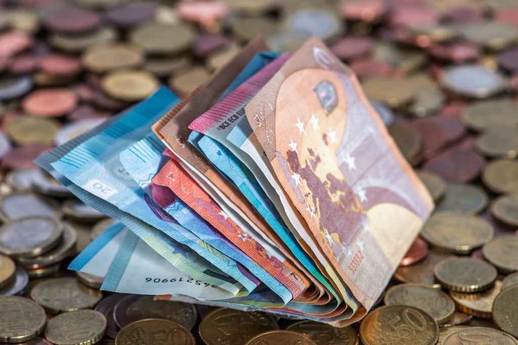 A pile of money sitting on top of a pile of coins